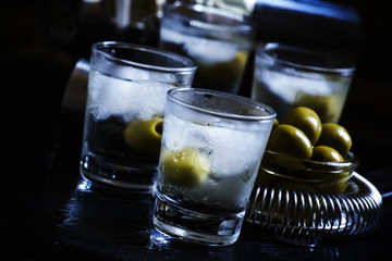 Cocktail with vodka, dry vermouth and green olives in the misted