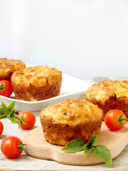 salty snack cakes muffins with cheese, tomatoes and basil - selective focus