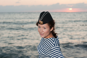 girl in a striped vest and his cap at the sea