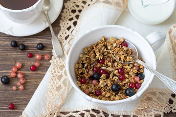 Homemade delicious healthy granola with nuts, seeds, honey and fresh berries in a ceramic cup