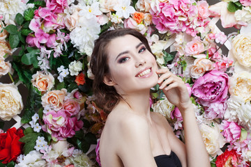Portrait of beautiful fashion girl, sweet, sensual. Beautiful makeup and messy romantic hairstyle. Flowers background. Green eyes.
