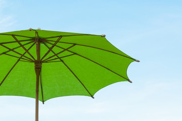 Traditional Asian paper and bamoo umbrella with a rounded handle on bluesky