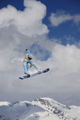 Naklejka na ściany i meble Snowboarder jumps on winter mountain.