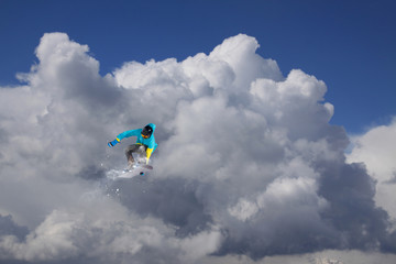 Naklejka na ściany i meble Snowboarder jumps on winter mountain.