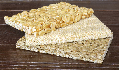 Brittles sesame, sunflower and peanut closeup Noah wooden background.