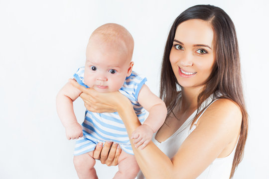 Happy mother holding a baby boy at white background