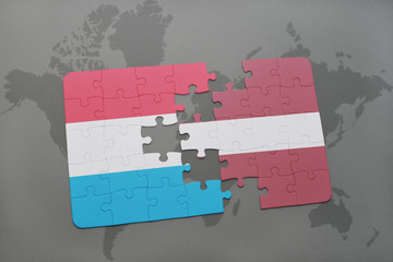 puzzle with the national flag of luxembourg and latvia on a world map background.