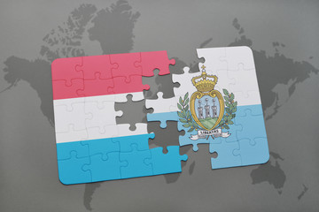 puzzle with the national flag of luxembourg and san marino on a world map background.