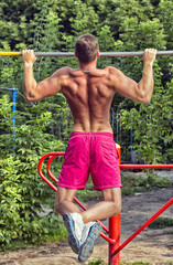 The young man goes in for sports in the brutal street playground