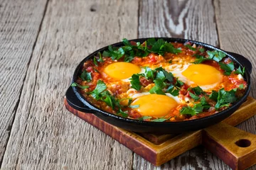 Outdoor-Kissen Egg dish with tomato sauce  served in  cast iron pan, shakshouka © istetiana