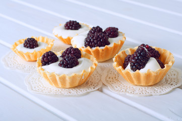 Tartlet with cream an fresh dewberries. Sweet berry summer desse