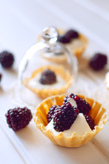 Tartlet with cream an fresh dewberries. Sweet berry summer desse