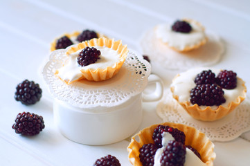 Tartlet with cream an fresh dewberries. Sweet berry summer desse