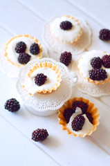 Tartlet with cream an fresh dewberries. Sweet berry summer desse
