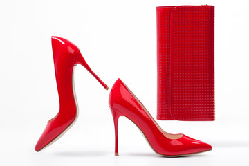 isolated red stylish stiletto shoes with clutch bag;
