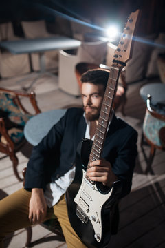 stylish bearded man with electric guitar;