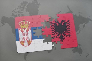 puzzle with the national flag of serbia and albania on a world map background.