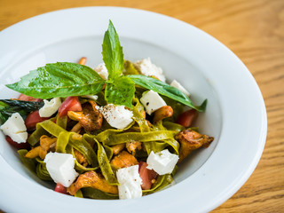 pasta with green pasta with chanterelle mushrooms, feta cheese and pepper