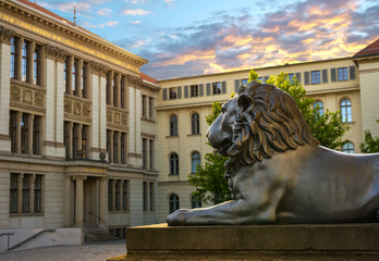 Old copper sculpture of a lion in front of the educational institution