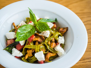 pasta with green pasta with chanterelle mushrooms, feta cheese and pepper