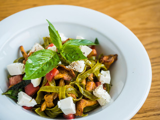 pasta with green pasta with chanterelle mushrooms, feta cheese and pepper