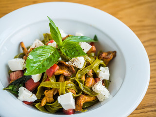 pasta with green pasta with chanterelle mushrooms, feta cheese and pepper