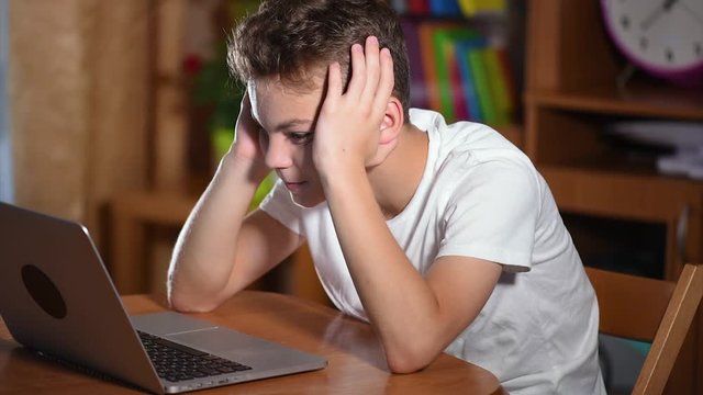 Teen boy working on laptop