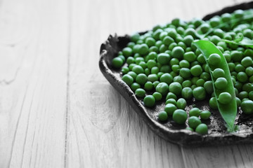 Fresh green peas on a black tray