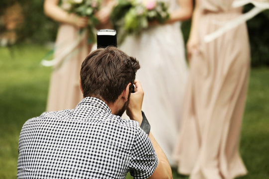 Photographer taking picture of bride with bridesmaids