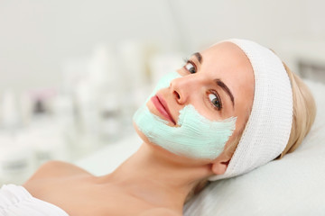 Young woman with facial mask in beauty salon