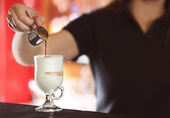 Woman hands preparing latte in cafe