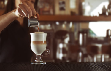 Woman hands preparing latte in cafe