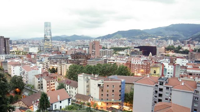 Time Lapse day to night of the city of Bilbao. View of the city on a cloudy day. District of Deusto in first term, taken from one of the hillsides surrounding the city.