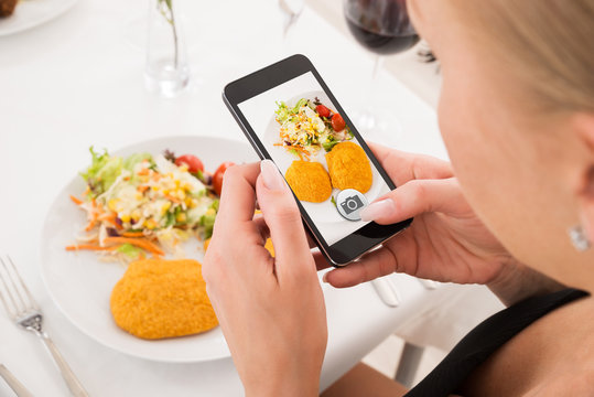 Woman Taking Picture Of Food With Mobile Phone