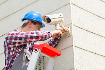 Technician Installing Camera On Wall