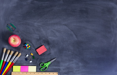 Simple back to school supplies on erased black chalkboard