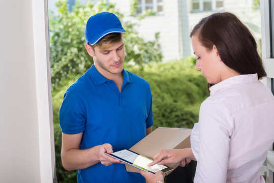 Woman Signing Receipt Of Delivery Package