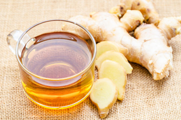 Ginger tea in glass and fresh ginger.