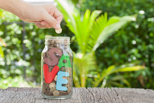 women hand putting money coin in jar. concept saving money  grow
