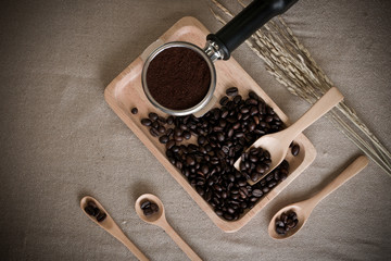 fresh coffee beans, wood spoons and coffee maker on the desktop