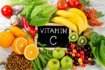 Foods High in vitamin C on a wooden board. - obrazy, fototapety, plakaty