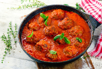 Homemade meatballs with spicy tomato sauce in a pan.