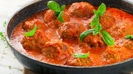 Beef meatballs with spicy tomato sauce in a pan - obrazy, fototapety, plakaty