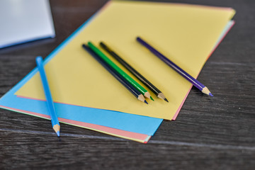 Blank paper and colorful pencils on the wooden table