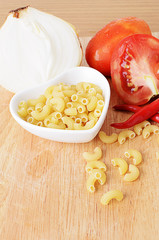 Macro close up of Elbow macaroni on wooden board with vertical b
