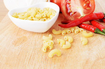 Macro close up of Elbow macaroni on wooden board