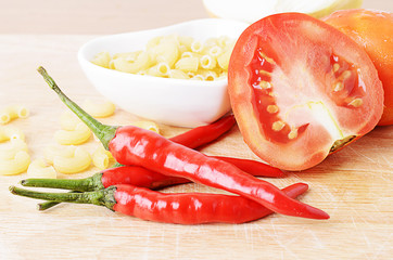 Macro close up of Red pepper chili and tomatoes and macaroni on