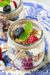 Glass jars with fruits and whipped cream.