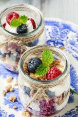 Glass jars with fruits and whipped cream.