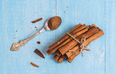 Ground cinnamon, sticks, tied with jute rope on old wooden background, selective focus, space for text,